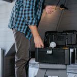 Man met gereedschapskist bereidt onderhoudswerk in huis voor ondanks stijgende kosten woningonderhoud