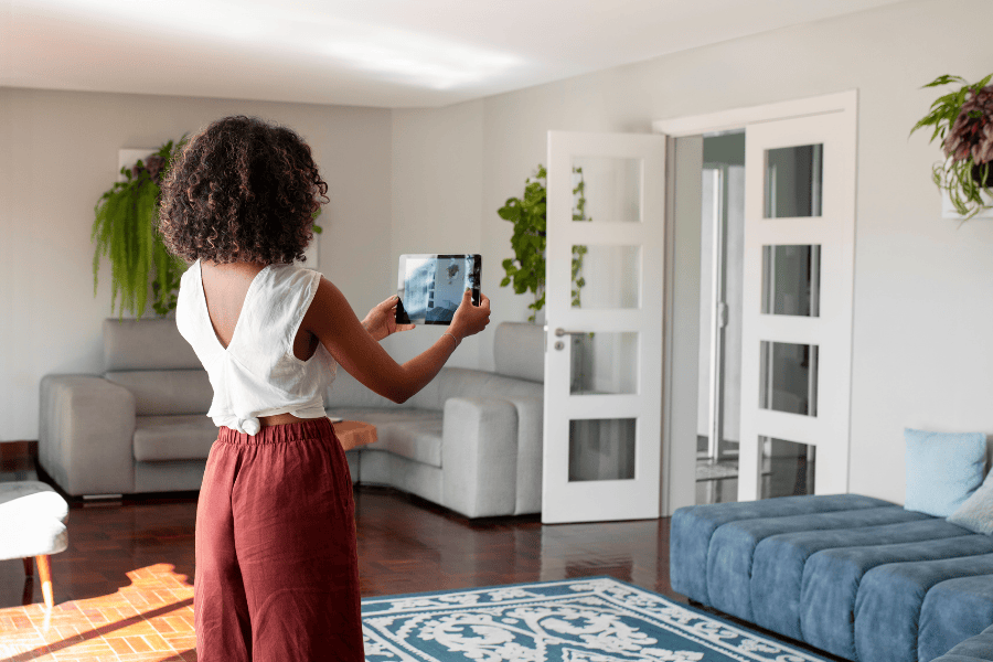 vrouw krullen ipad foto maken bezichtigen woning bank tapijt 